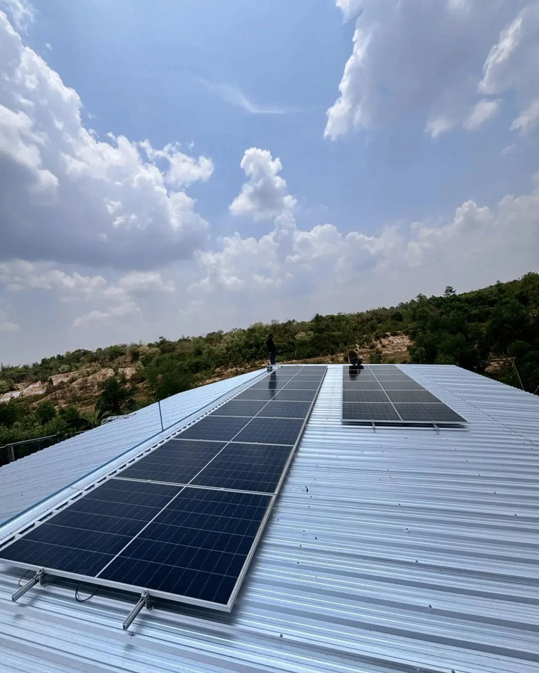Solar installation on metal roof with workers